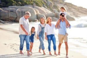 Big family walikng on the ocean bech