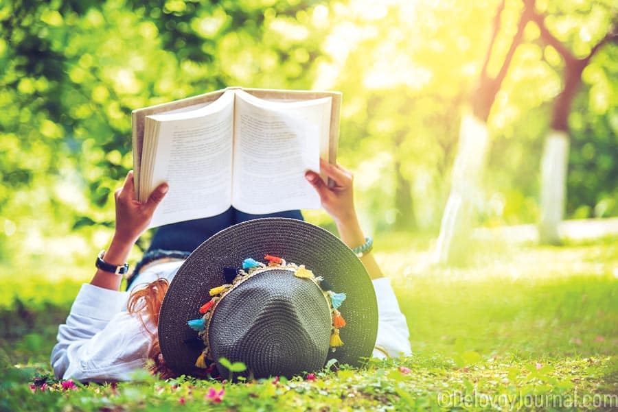 Reading a book laying on a grass